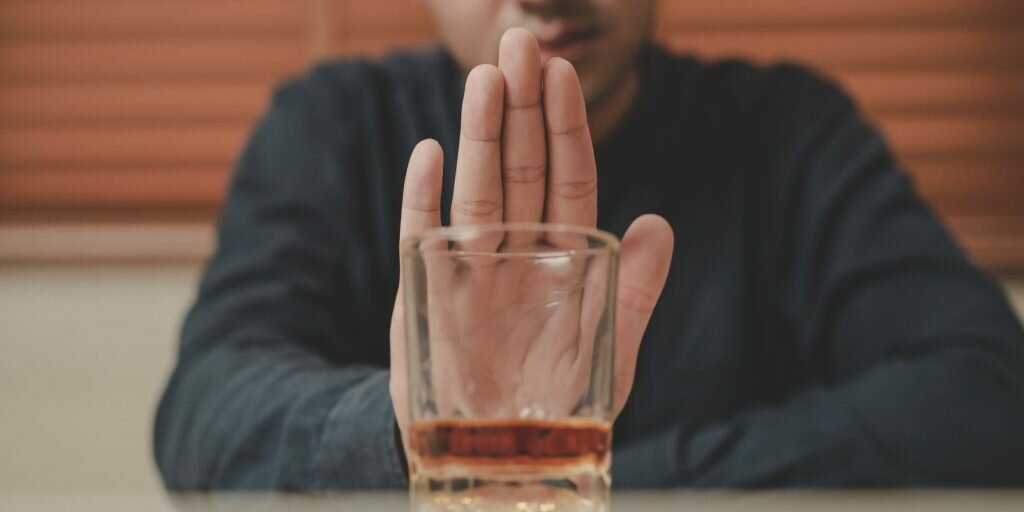 Man fighting alcohol urge and refusing to drink