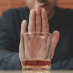 Man fighting alcohol urge and refusing to drink